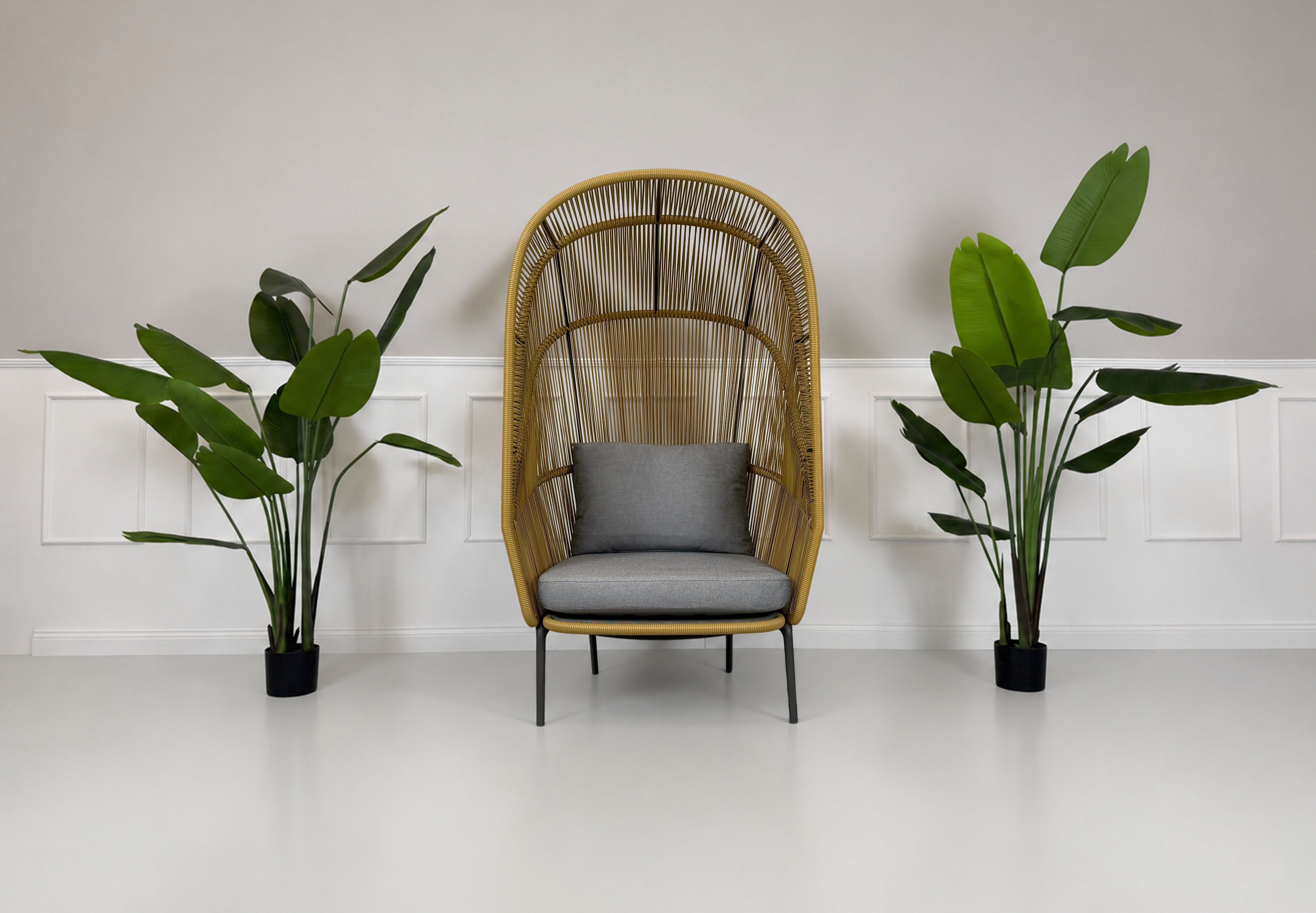 Gebrauchter outdoor DEDON Rilly Cocoon Garten Stuhl vor einer Wand, stilvoll und modern eingerichtet.