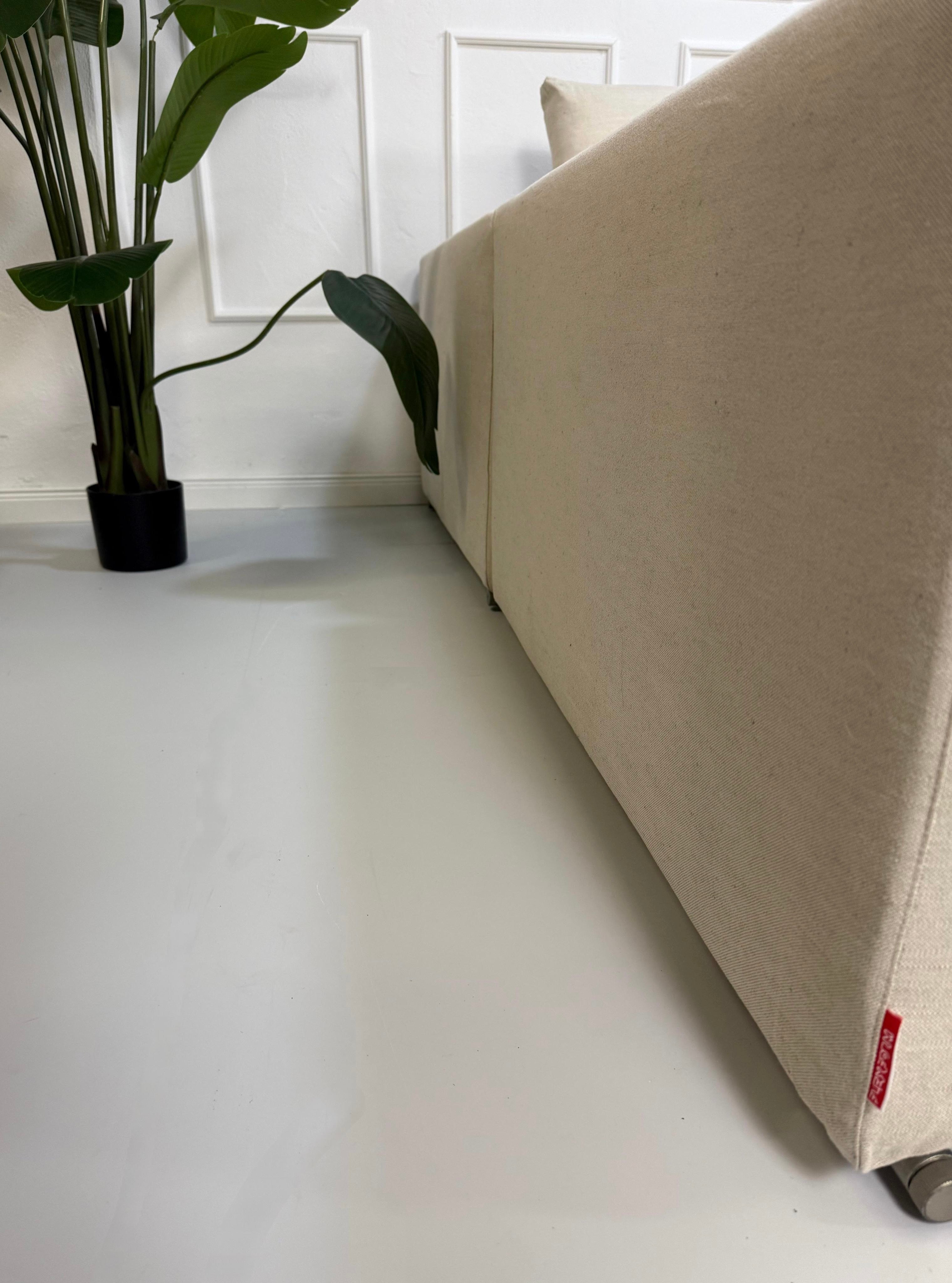 Gebrauchtes beiges Flexform Groundpiece Designer Stoff Sofa vor einer Wand, stilvoll und modern eingerichtet.