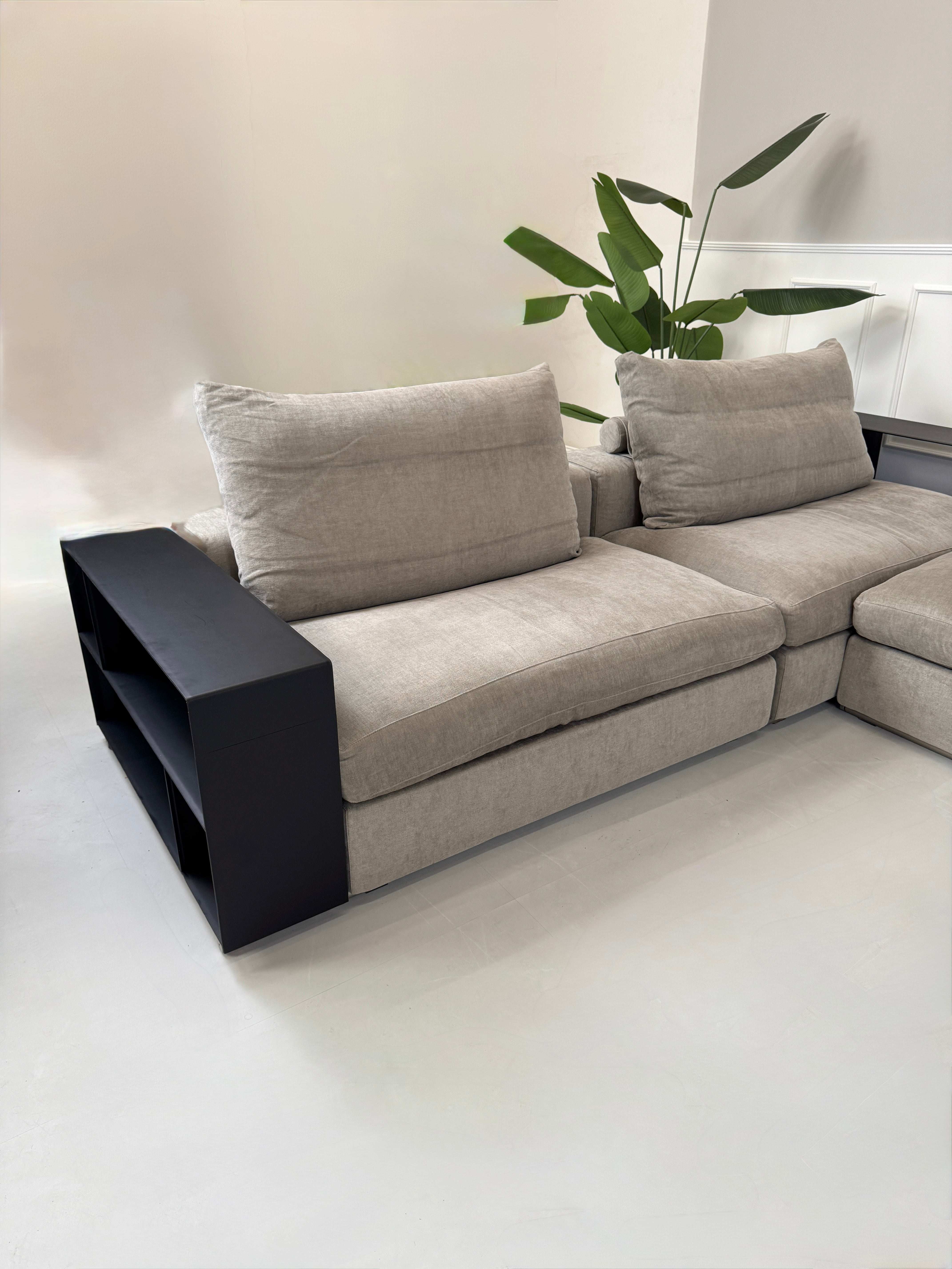 Gebrauchtes graues Flexform Groundpiece Designer Stoff Sofa vor einer Wand, stilvoll und modern eingerichtet.