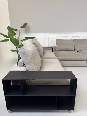 Gebrauchtes graues Flexform Groundpiece Designer Stoff Sofa vor einer Wand, stilvoll und modern eingerichtet.