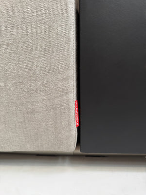 Gebrauchtes graues Flexform Groundpiece Designer Stoff Sofa vor einer Wand, stilvoll und modern eingerichtet.
