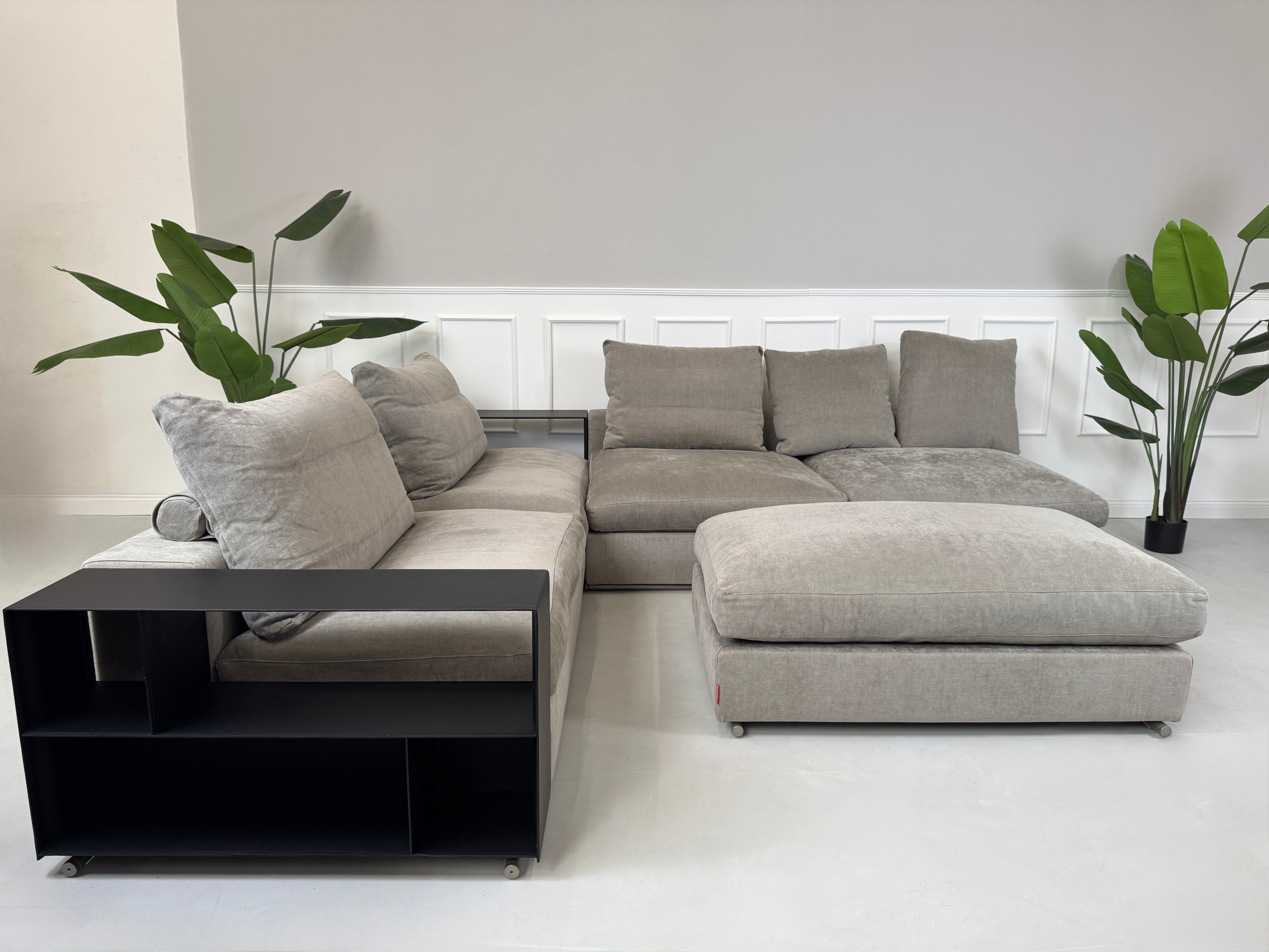 Gebrauchtes graues Flexform Groundpiece Designer Stoff Sofa vor einer Wand, stilvoll und modern eingerichtet.