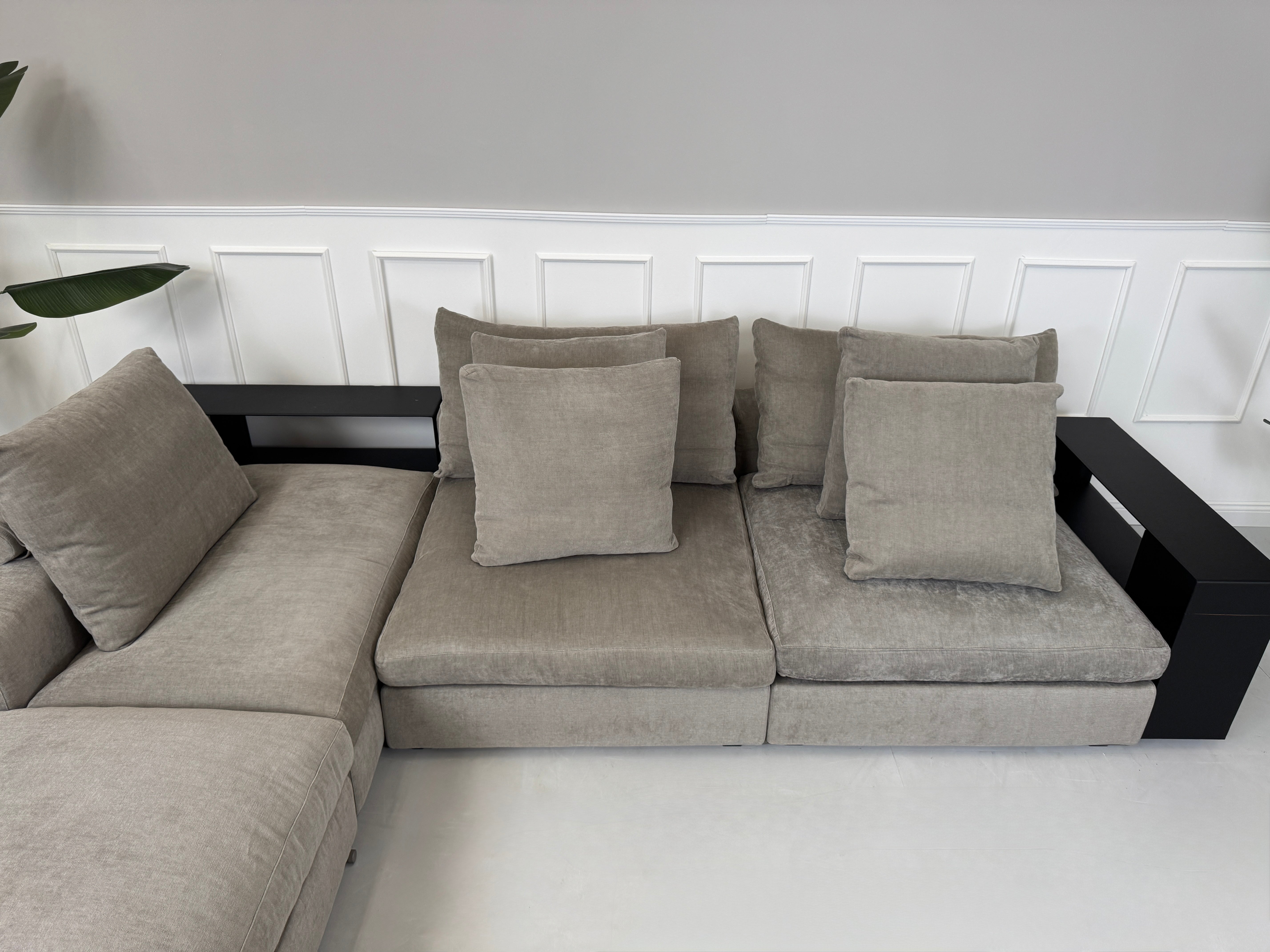 Gebrauchtes graues Flexform Groundpiece Designer Stoff Sofa vor einer Wand, stilvoll und modern eingerichtet.