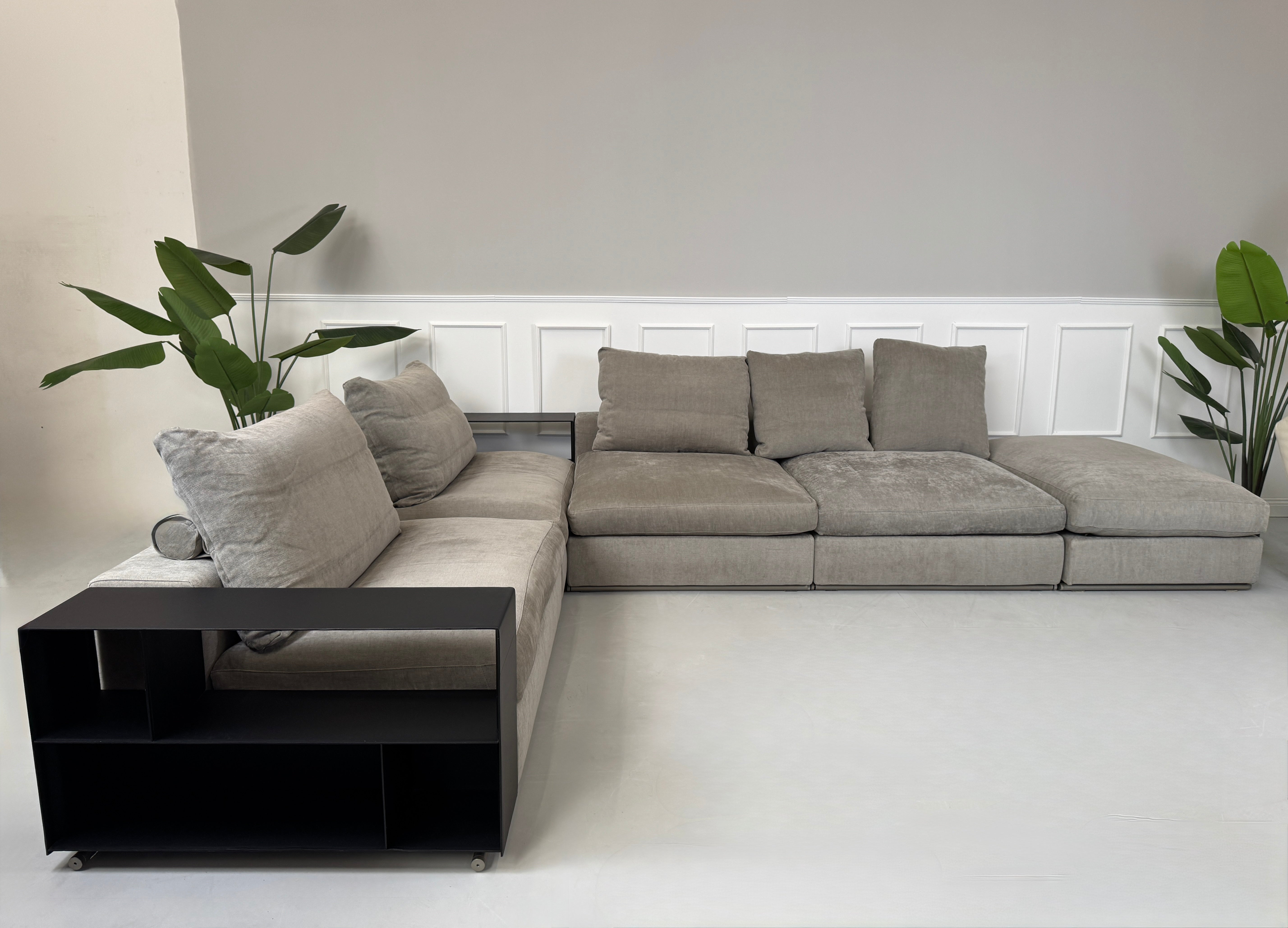Gebrauchtes graues Flexform Groundpiece Designer Stoff Sofa vor einer Wand, stilvoll und modern eingerichtet.