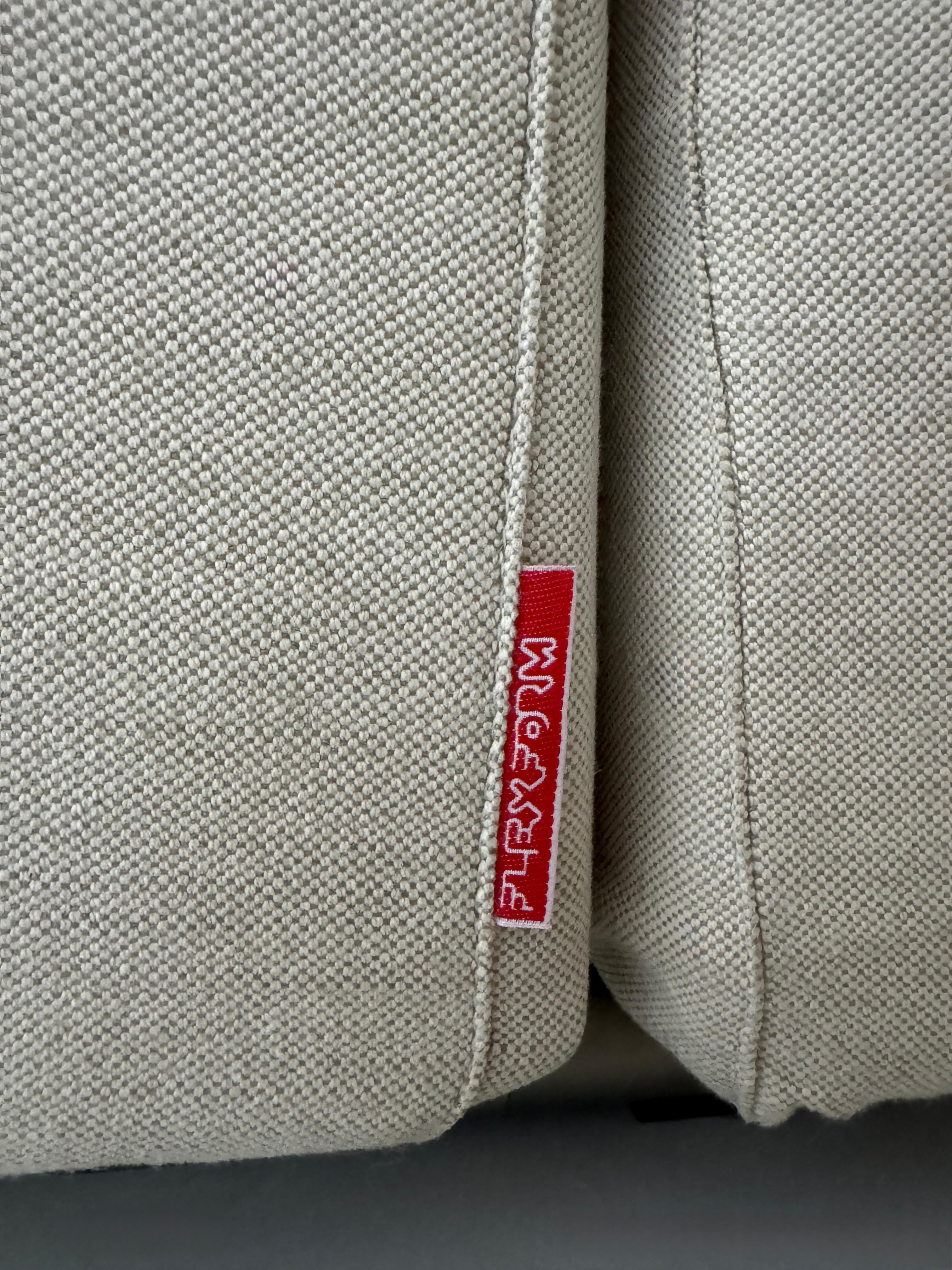 Gebrauchtes beiges Flexform Groundpiece Designer Stoff Sofa vor einer Wand, stilvoll und modern eingerichtet.