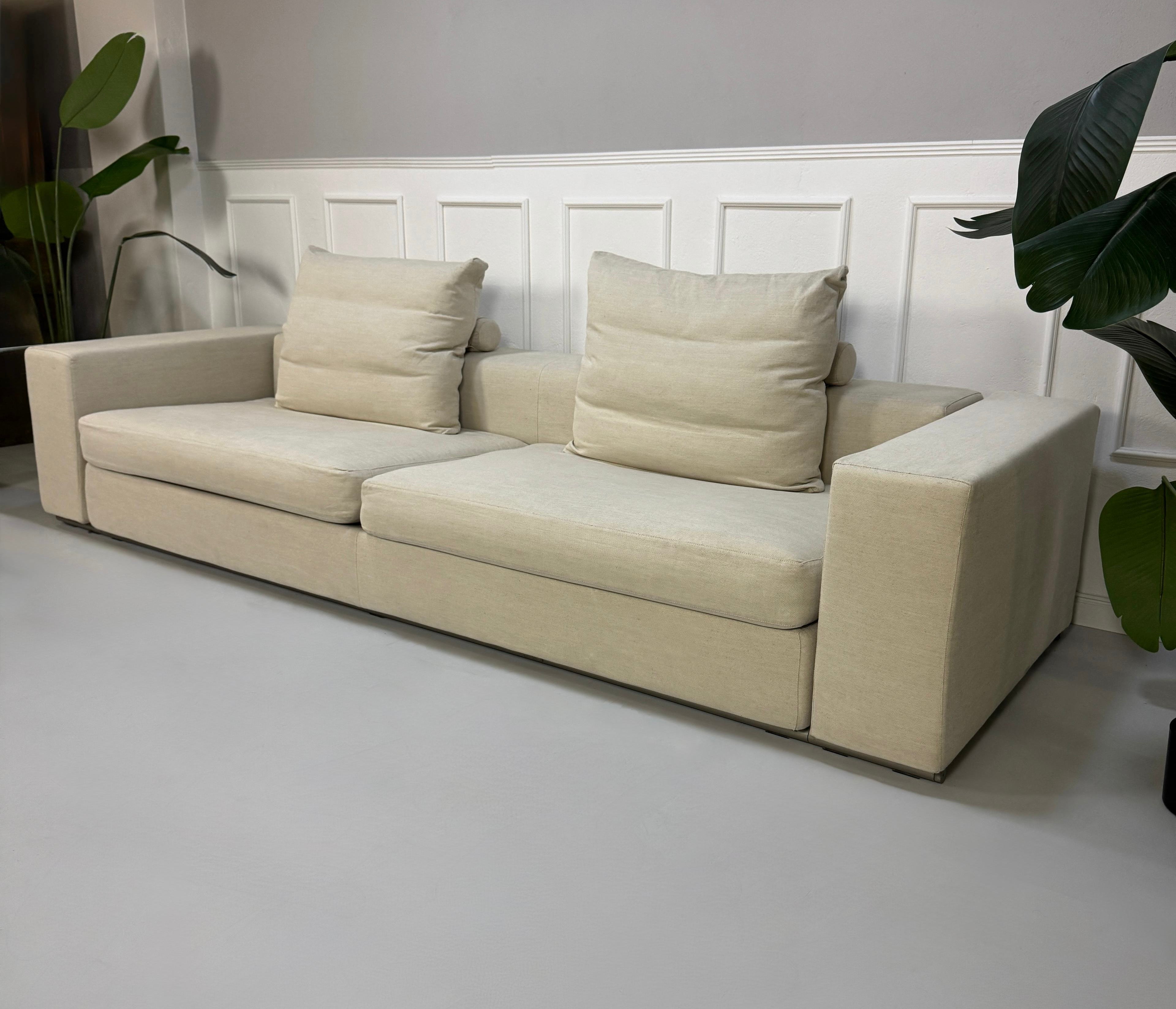 Gebrauchtes beiges Flexform Groundpiece Designer Stoff Sofa vor einer Wand, stilvoll und modern eingerichtet.