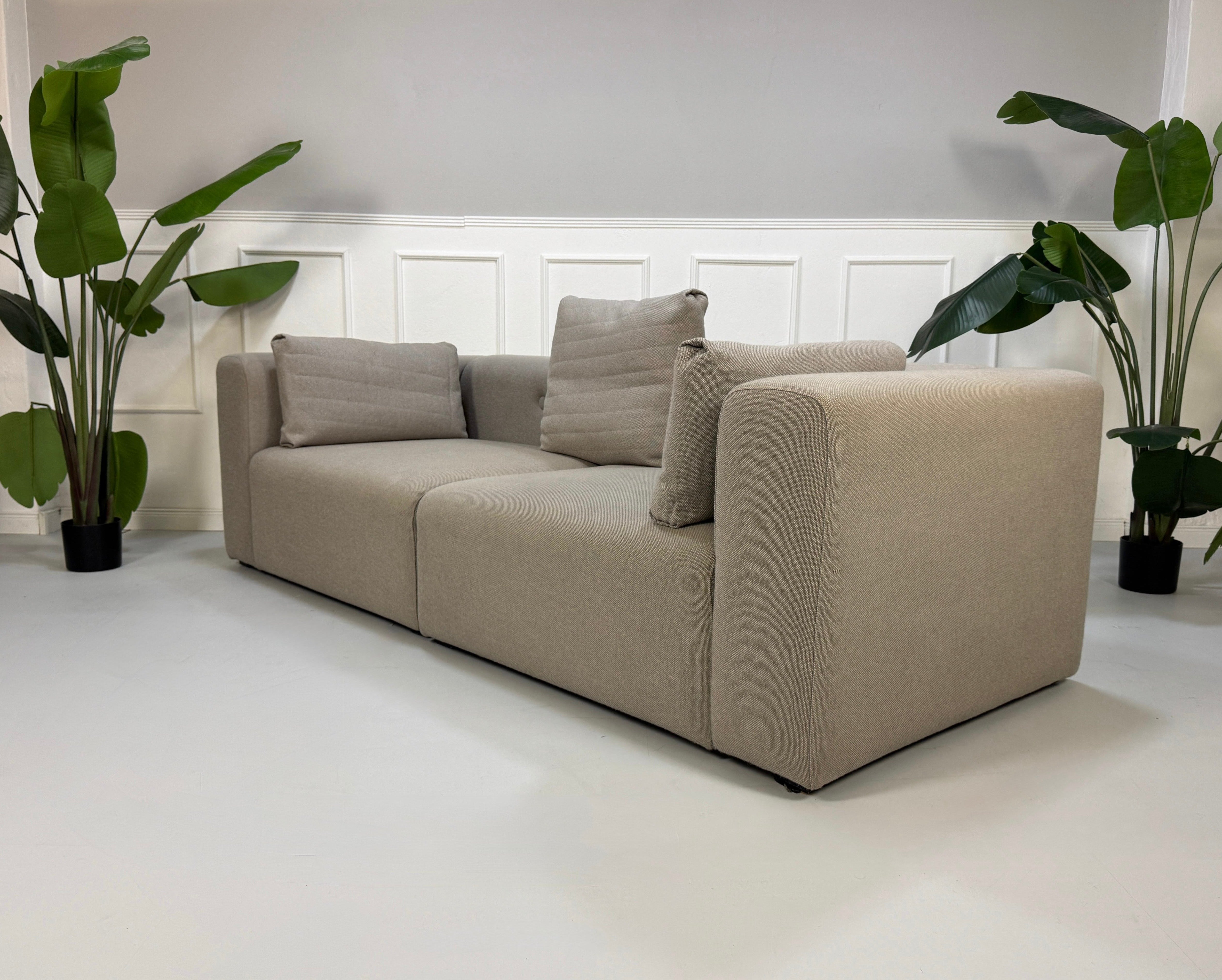Gebrauchtes graues HAY Mags Designer Stoff Sofa vor einer Wand, stilvoll und modern eingerichtet.