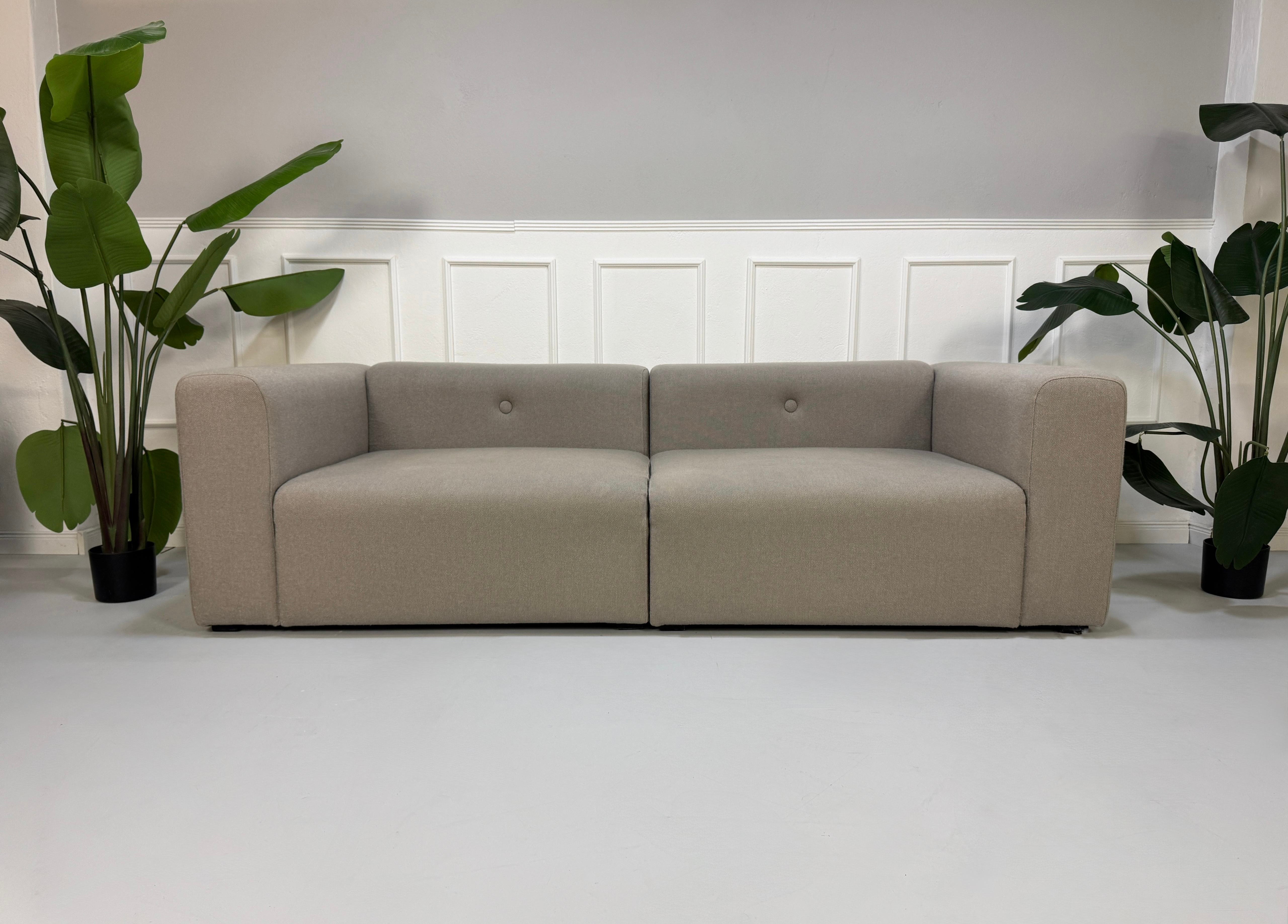 Gebrauchtes graues HAY Mags Designer Stoff Sofa vor einer Wand, stilvoll und modern eingerichtet.