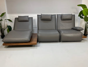 Gebrauchtes graues Koinor Epos Designer Leder Sofa vor einer Wand, stilvoll und modern eingerichtet.