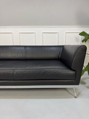Gebrauchtes schwarzes Ligne Roset Fugue Designer Leder Sofa vor einer Wand, stilvoll und modern eingerichtet.