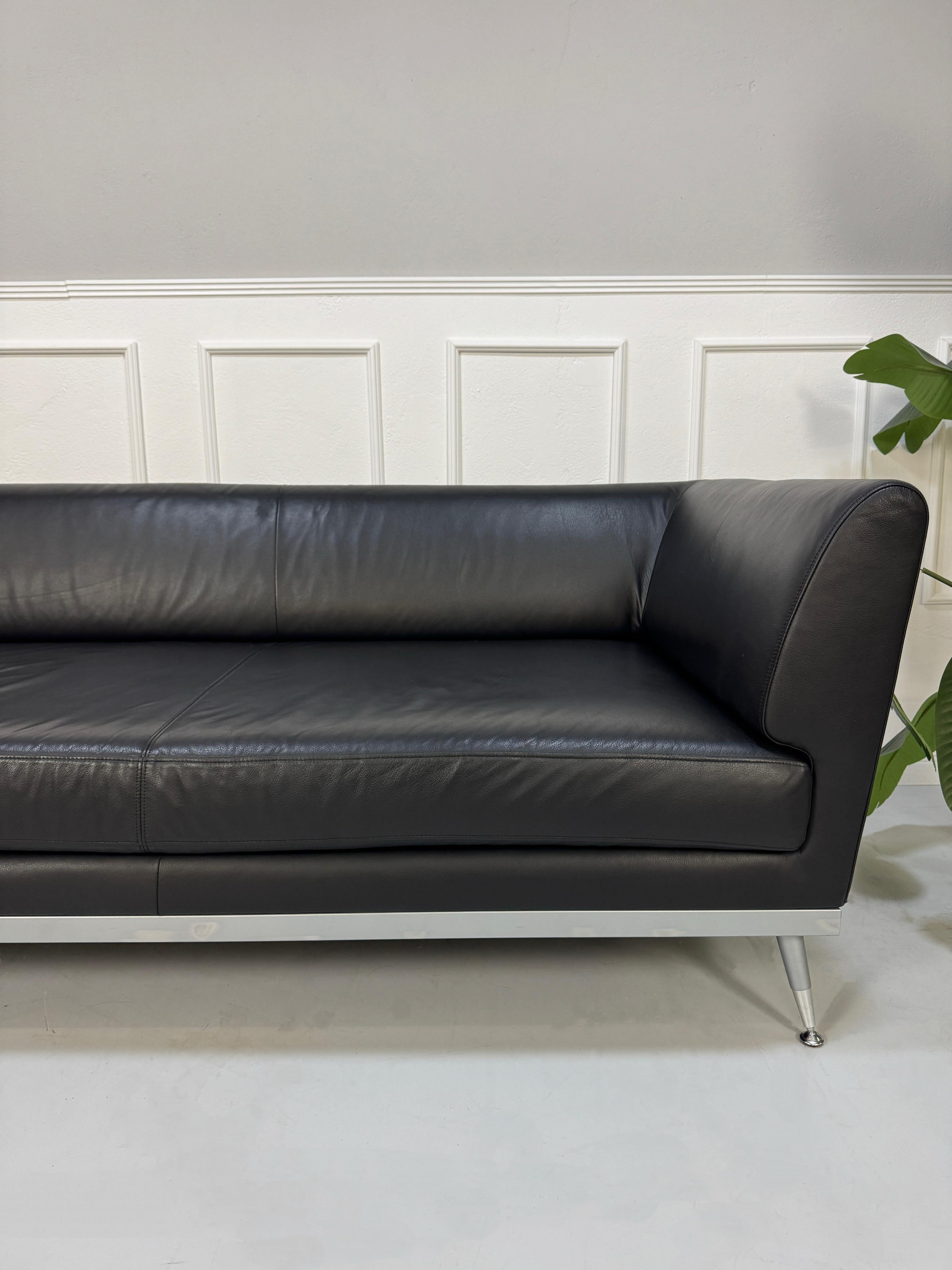 Gebrauchtes schwarzes Ligne Roset Fugue Designer Leder Sofa vor einer Wand, stilvoll und modern eingerichtet.