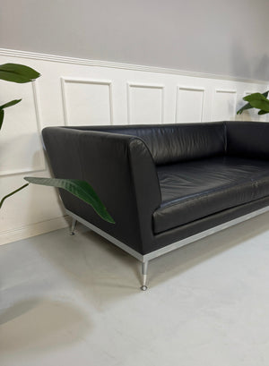 Gebrauchtes schwarzes Ligne Roset Fugue Designer Leder Sofa vor einer Wand, stilvoll und modern eingerichtet.