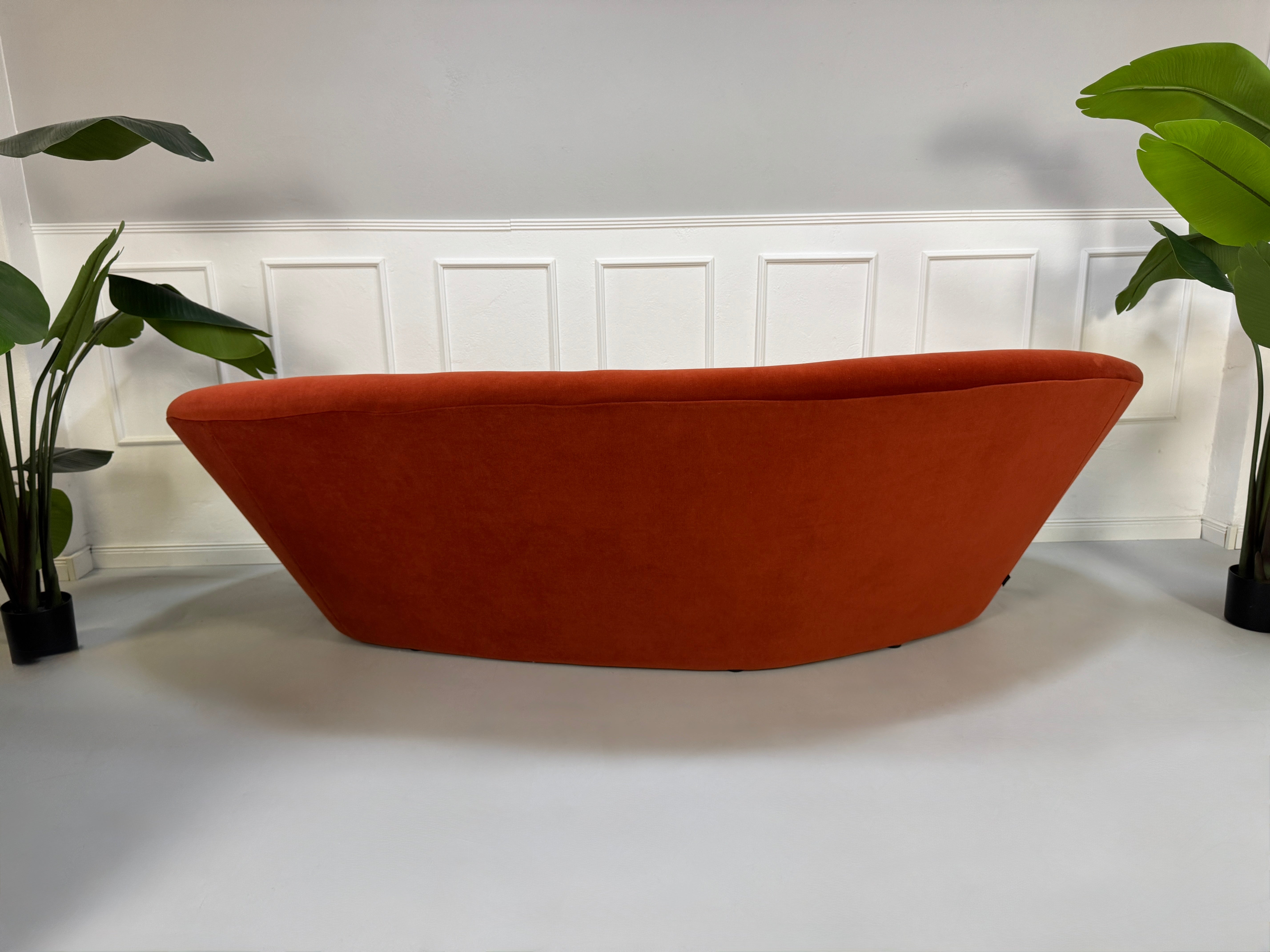 Ligne Roset Ploum in der Farbe Orange Designer Stoff Sofa vor einer Wand, stilvoll und modern eingerichtet.