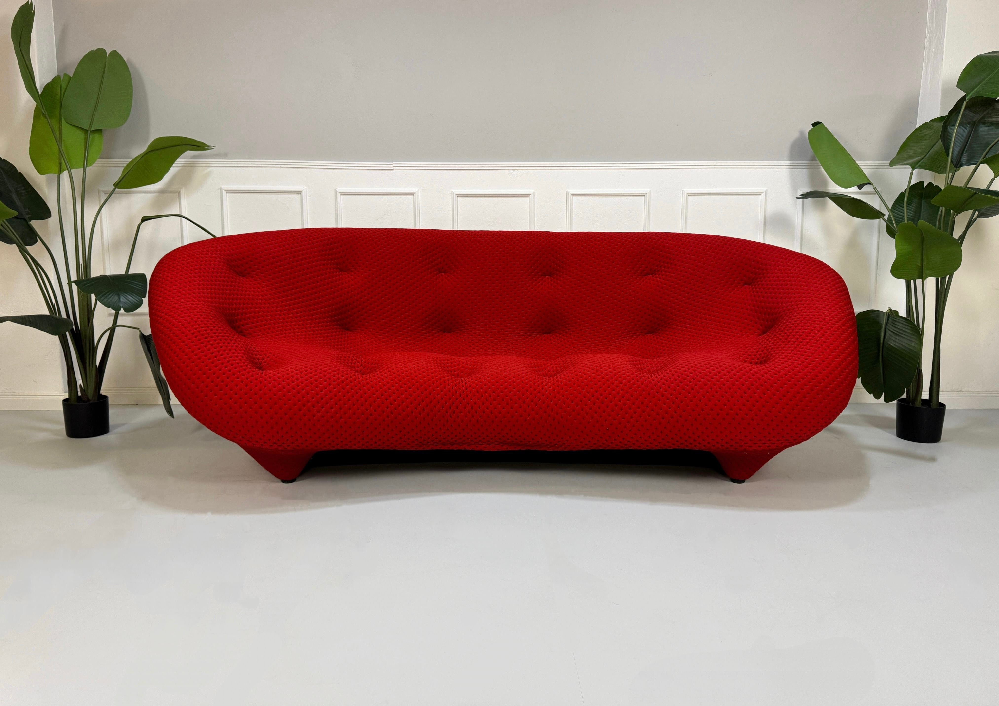 Gebrauchtes Ligne Roset Ploum Stoff Sofa in der Farbe Rot vor einer Wand, stilvoll und modern eingerichtet.