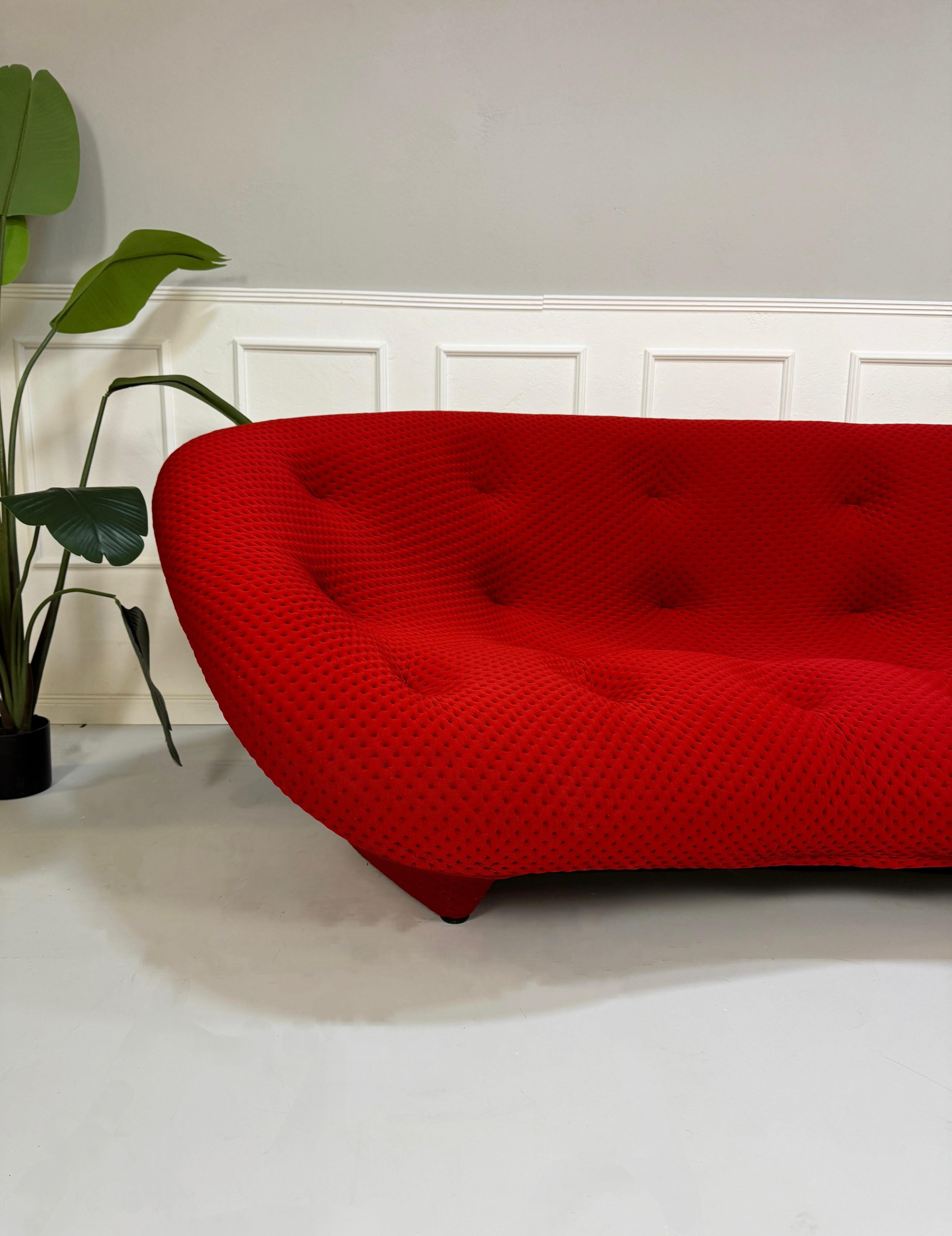 Gebrauchtes Ligne Roset Ploum Stoff Sofa in der Farbe Rot vor einer Wand, stilvoll und modern eingerichtet.