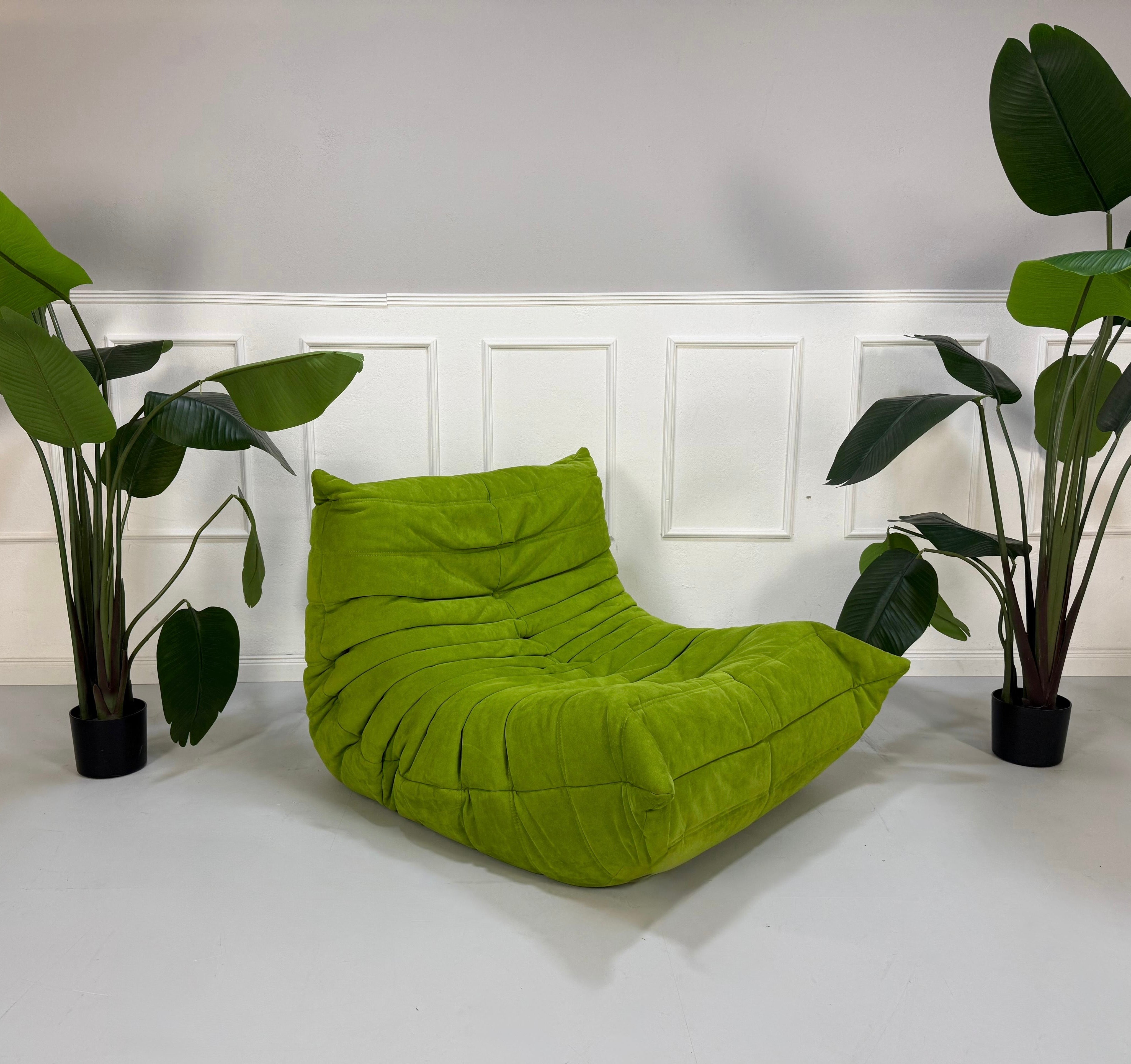 Erneuertes Ligne Roset Togo Designer Stoff Sofa in der Farbe Grün vor einer Wand, stilvoll und modern eingerichtet.
