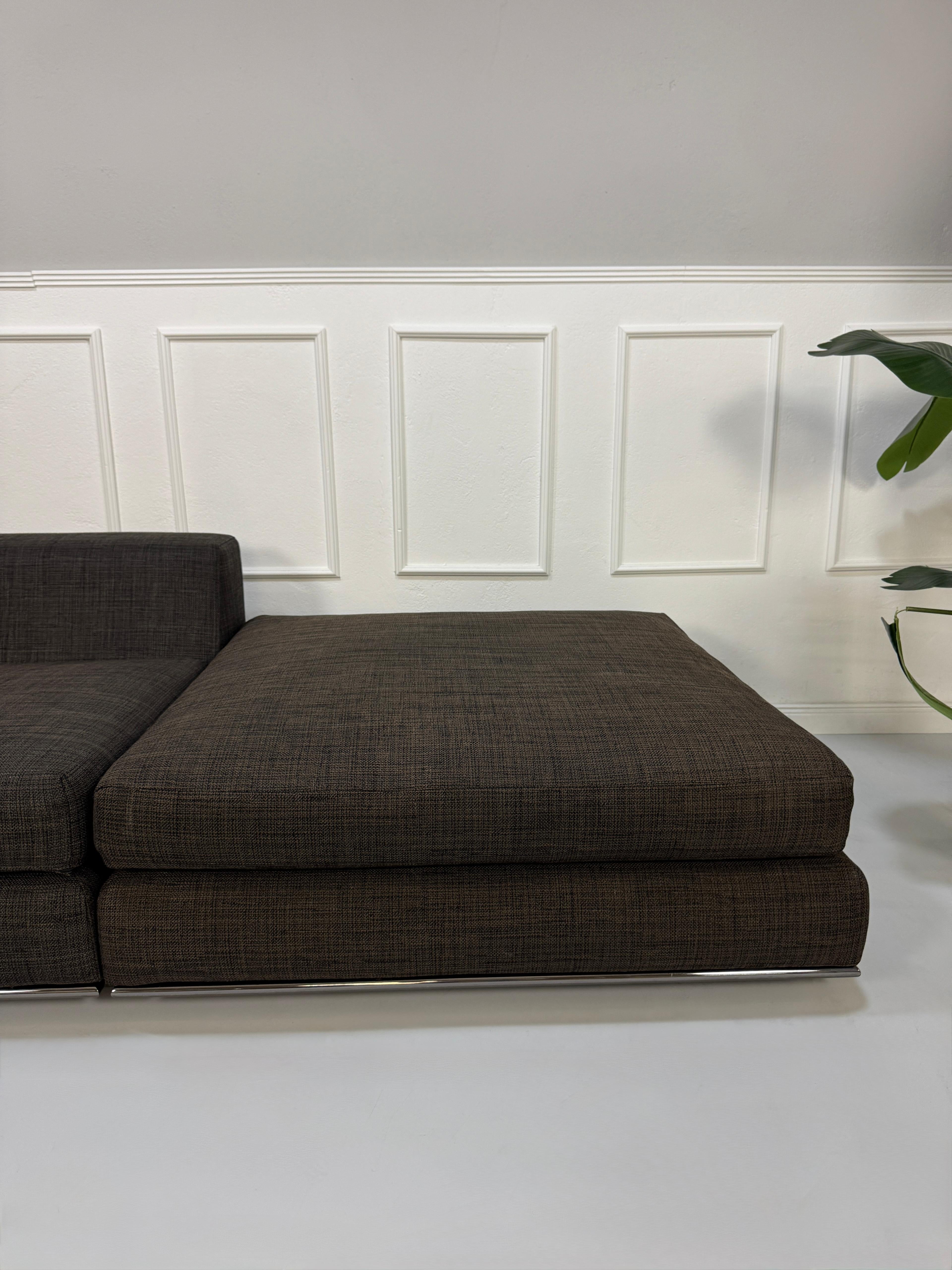 Gebrauchtes braunes Minotti Hamilton Designer Stoff Sofa vor einer Wand, stilvoll und modern eingerichtet.