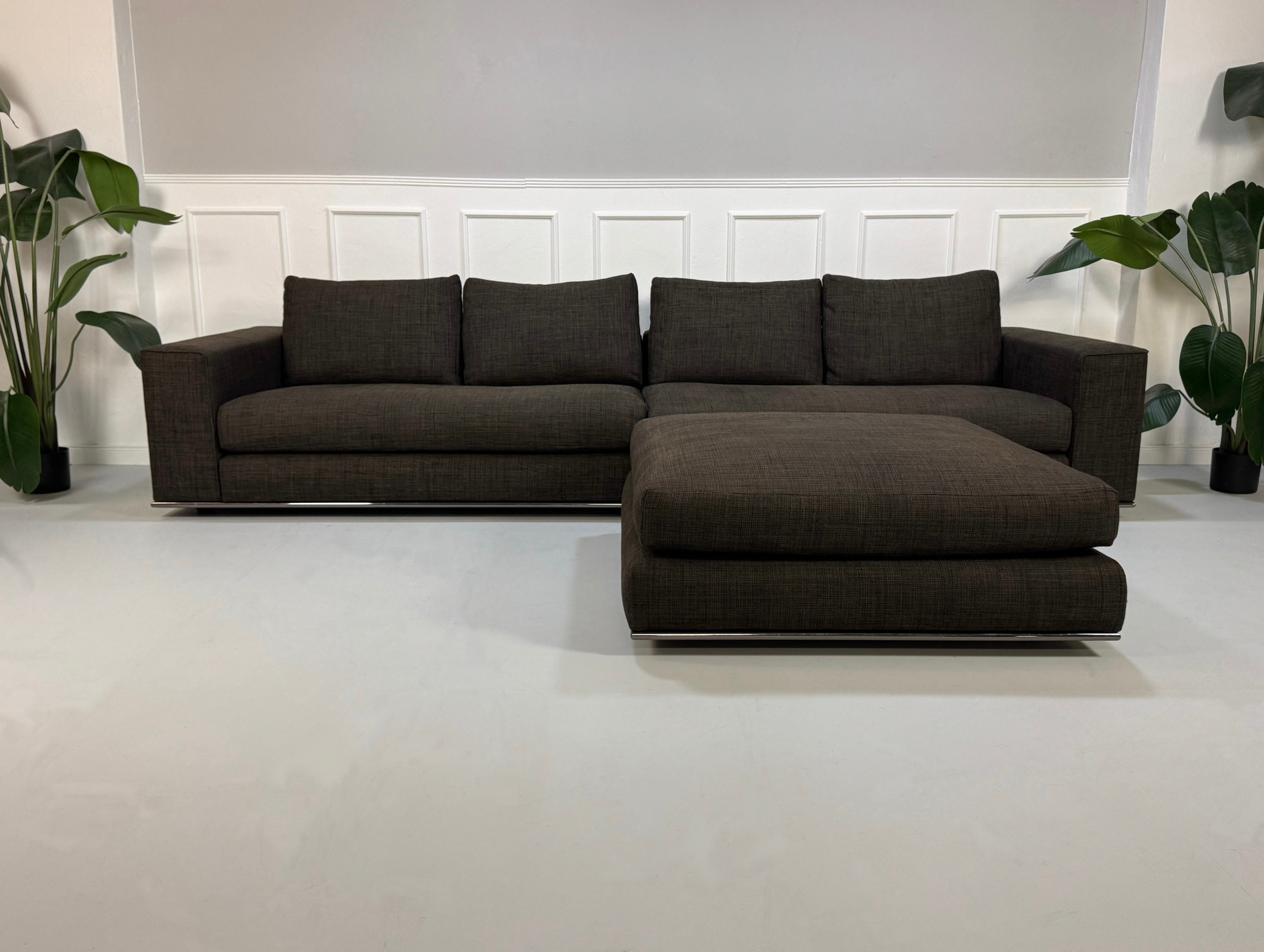 Gebrauchtes braunes Minotti Hamilton Designer Stoff Sofa vor einer Wand, stilvoll und modern eingerichtet.