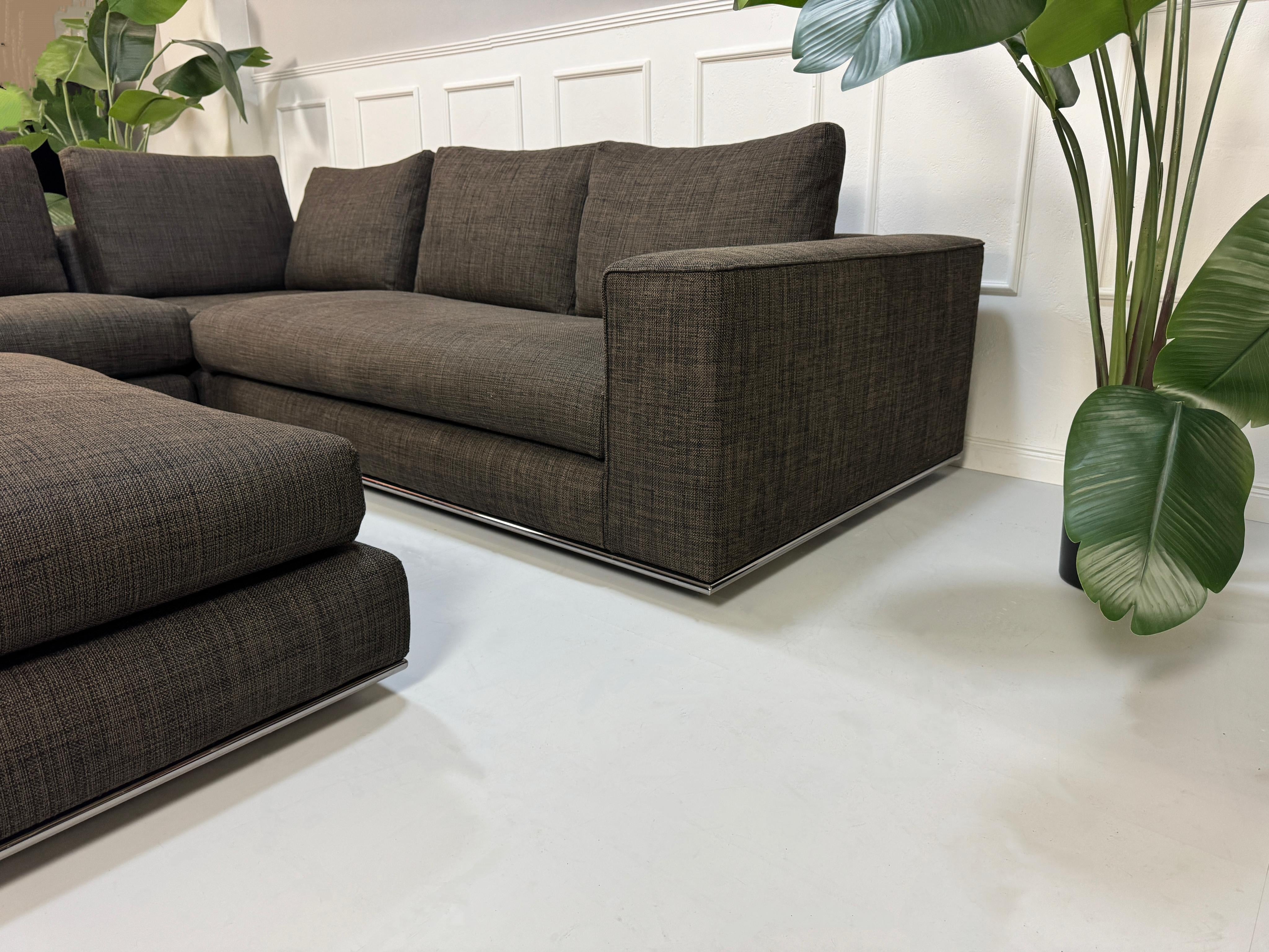 Gebrauchtes braunes Minotti Hamilton Designer Stoff Sofa vor einer Wand, stilvoll und modern eingerichtet.
