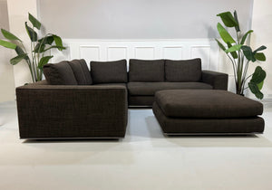 Gebrauchtes braunes Minotti Hamilton Designer Stoff Sofa vor einer Wand, stilvoll und modern eingerichtet.