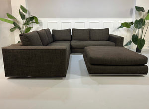Gebrauchtes braunes Minotti Hamilton Designer Stoff Sofa vor einer Wand, stilvoll und modern eingerichtet.