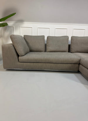 Gebrauchtes graues Minotti Hamilton Designer Stoff Sofa vor einer Wand, stilvoll und modern eingerichtet.