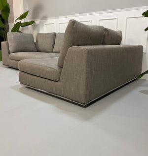 Gebrauchtes graues Minotti Hamilton Designer Stoff Sofa vor einer Wand, stilvoll und modern eingerichtet.