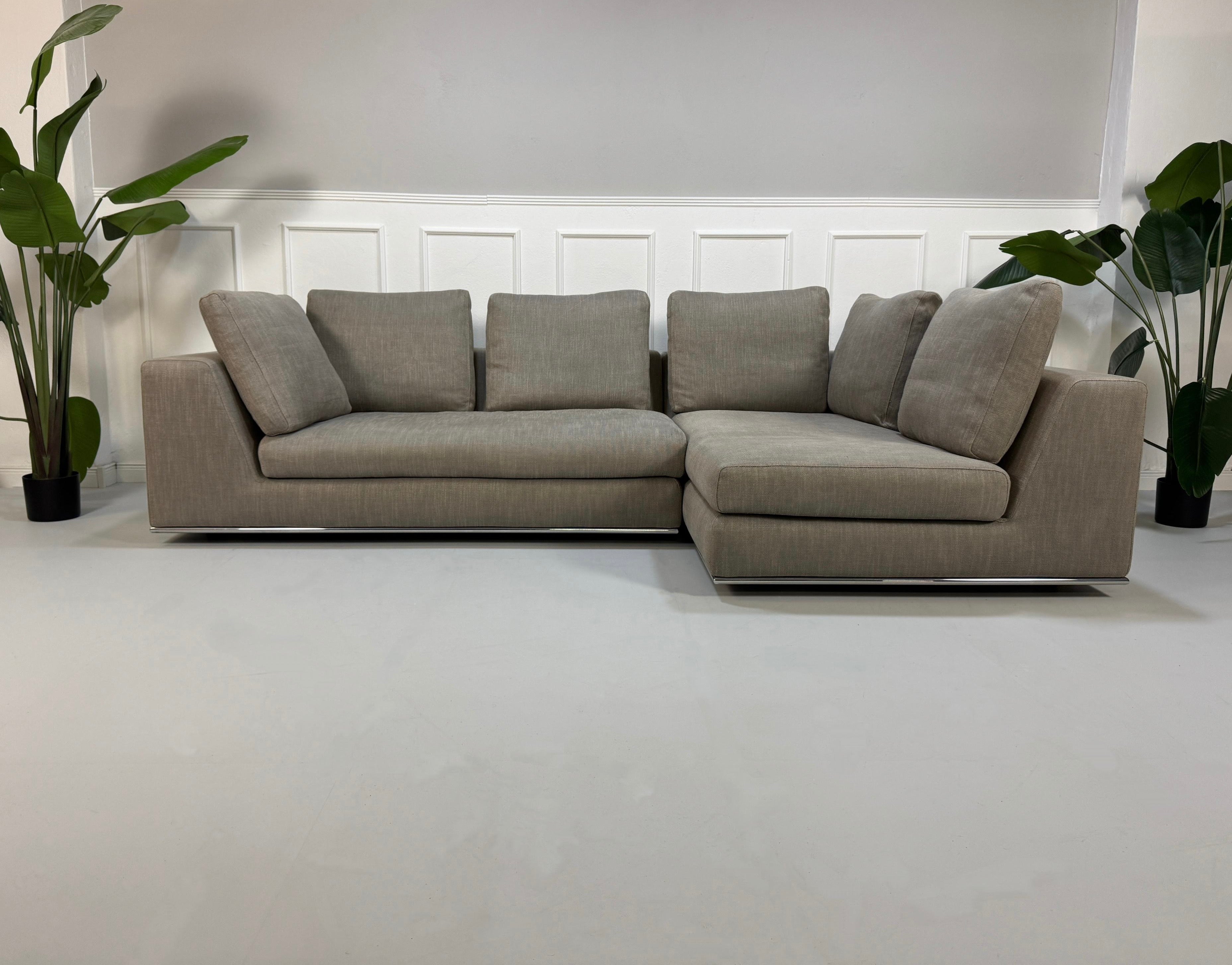 Gebrauchtes graues Minotti Hamilton Designer Stoff Sofa vor einer Wand, stilvoll und modern eingerichtet.