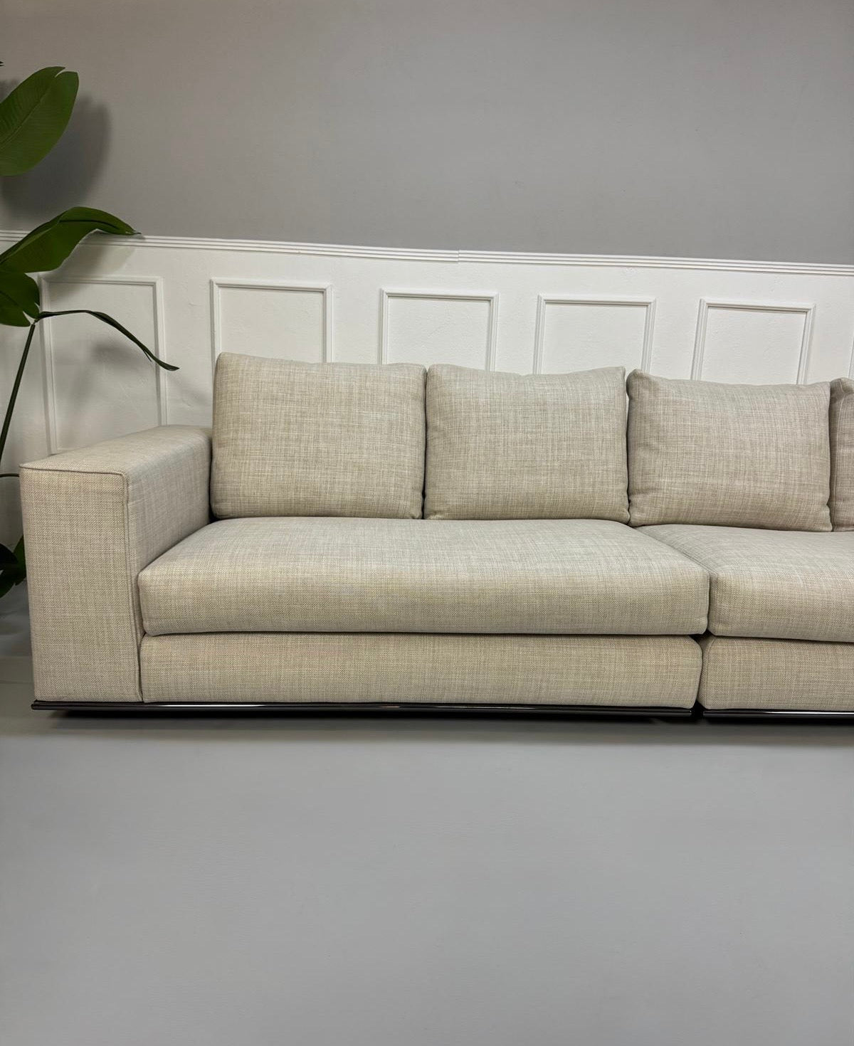 Gebrauchtes beiges Minotti Hamilton Designer Stoff Sofa vor einer Wand, stilvoll und modern eingerichtet.