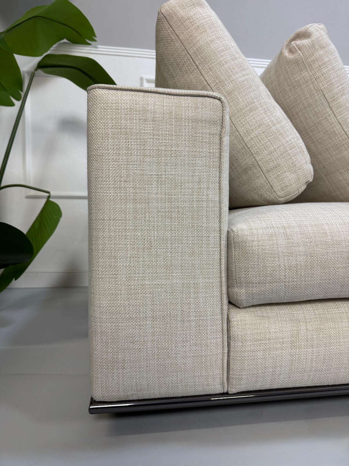 Gebrauchtes beiges Minotti Hamilton Designer Stoff Sofa vor einer Wand, stilvoll und modern eingerichtet.