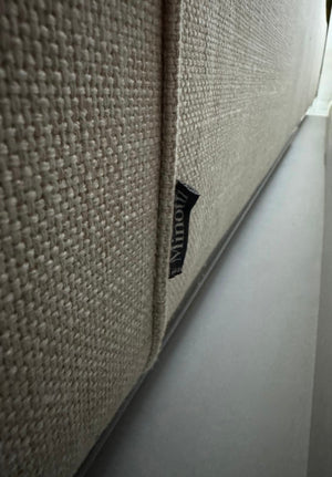 Gebrauchtes beiges Minotti Hamilton Designer Stoff Sofa vor einer Wand, stilvoll und modern eingerichtet.