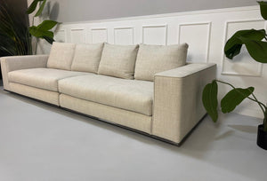 Gebrauchtes beiges Minotti Hamilton Designer Stoff Sofa vor einer Wand, stilvoll und modern eingerichtet.