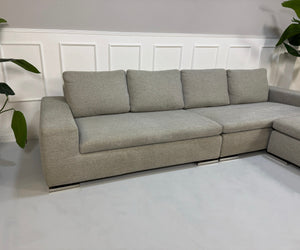 Gebrauchtes graues Minotti Moore Designer Stoff Sofa vor einer Wand, stilvoll und modern eingerichtet.