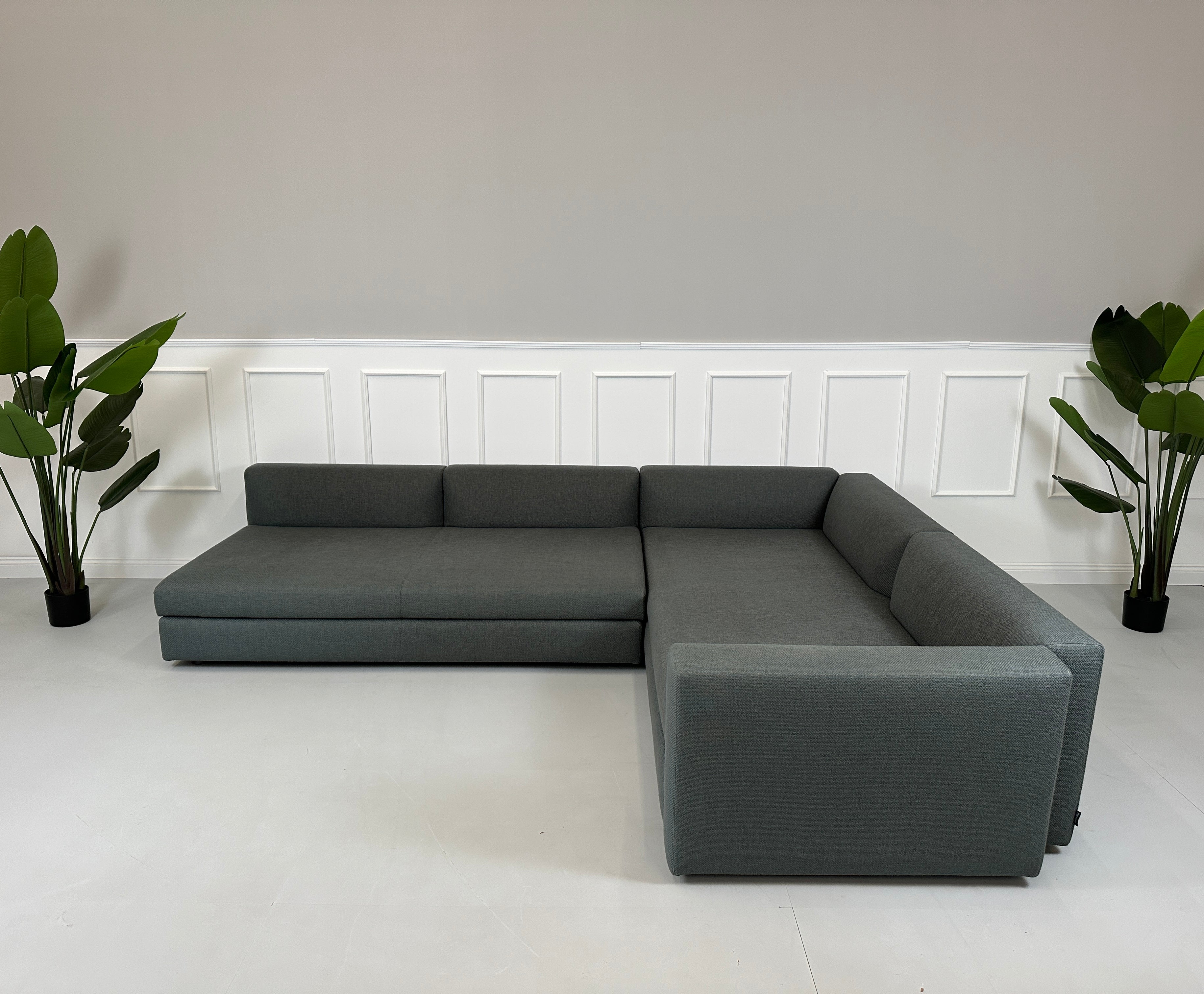 Gebrauchtes grünes Minotti Kline Designer Stoff Sofa vor einer Wand, stilvoll und modern eingerichtet mit Tisch.