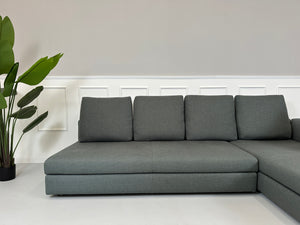 Gebrauchtes grünes Minotti Kline Designer Stoff Sofa vor einer Wand, stilvoll und modern eingerichtet mit Tisch.