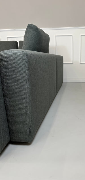 Gebrauchtes grünes Minotti Kline Designer Stoff Sofa vor einer Wand, stilvoll und modern eingerichtet mit Tisch.