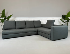 Gebrauchtes grünes Minotti Kline Designer Stoff Sofa vor einer Wand, stilvoll und modern eingerichtet mit Tisch.