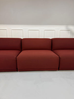 Gebrauchtes rotes Muuto Connect  Designer Stoff Sofa vor einer Wand, stilvoll und modern eingerichtet.