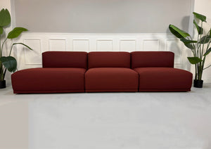 Gebrauchtes rotes Muuto Connect  Designer Stoff Sofa vor einer Wand, stilvoll und modern eingerichtet.