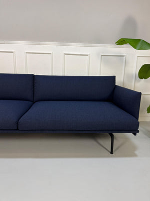 Gebrauchtes blaues Muuto Outline Designer Stoff Sofa vor einer Wand, stilvoll und modern eingerichtet.