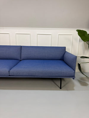 Gebrauchtes blaues Muuto Outline Designer Stoff Sofa vor einer Wand, stilvoll und modern eingerichtet.