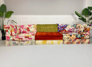 Gebrauchtes buntes Roche Bobois Mah Jong Designer Stoff Sofa vor einer Wand, stilvoll und modern eingerichtet.