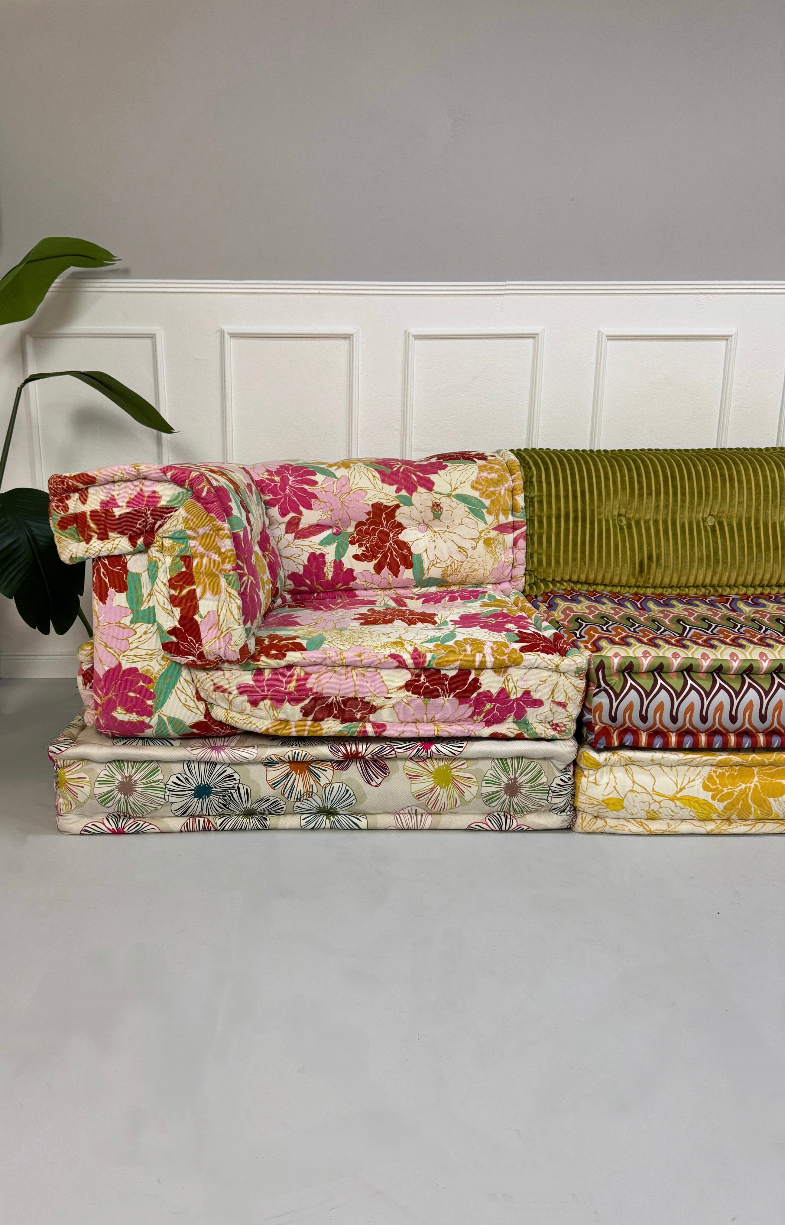 Gebrauchtes buntes Roche Bobois Mah Jong Designer Stoff Sofa vor einer Wand, stilvoll und modern eingerichtet.