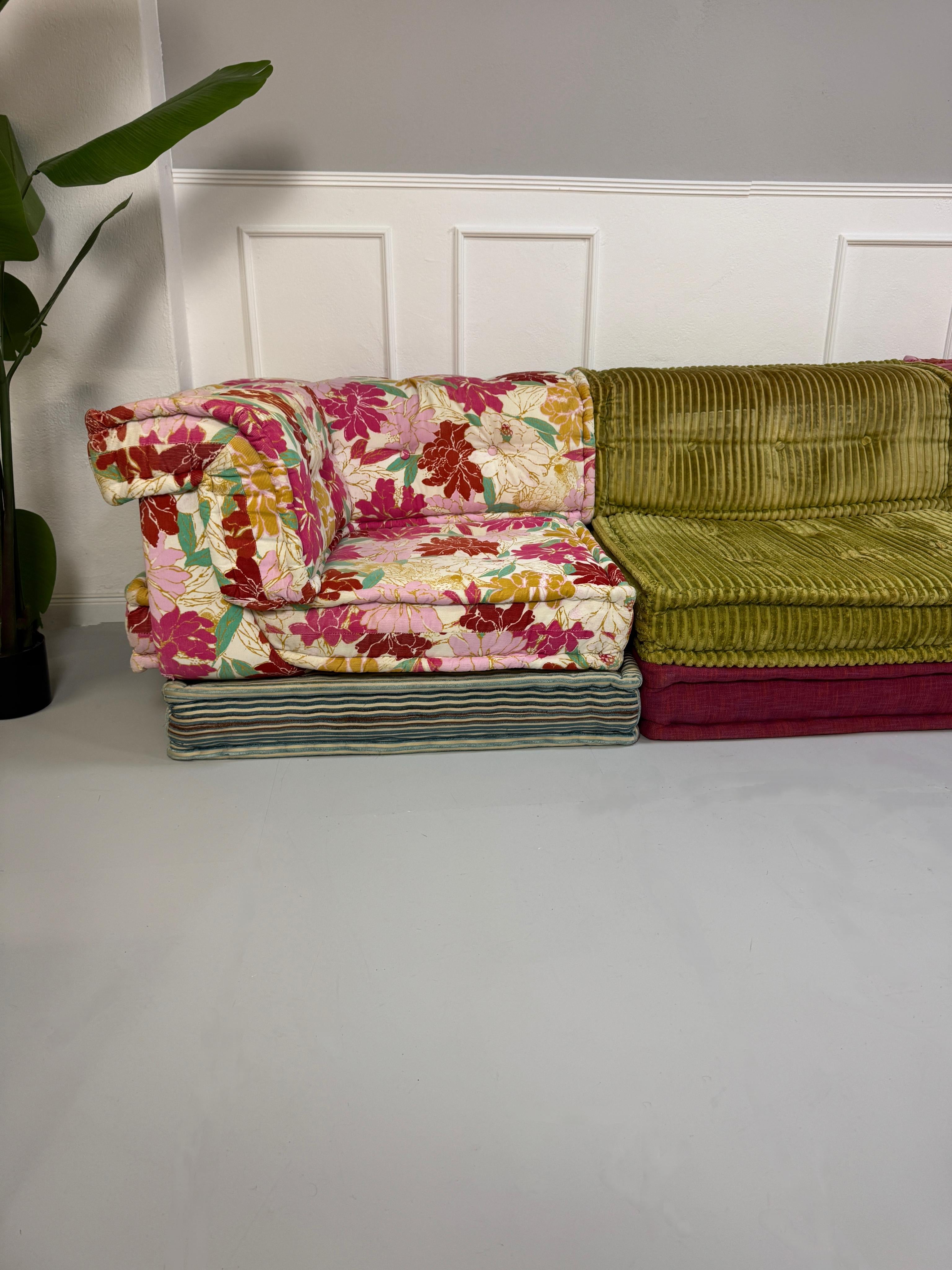 Gebrauchtes buntes Roche Bobois MahJongDesigner Stoff Sofa vor einer Wand, stilvoll und modern eingerichtet.