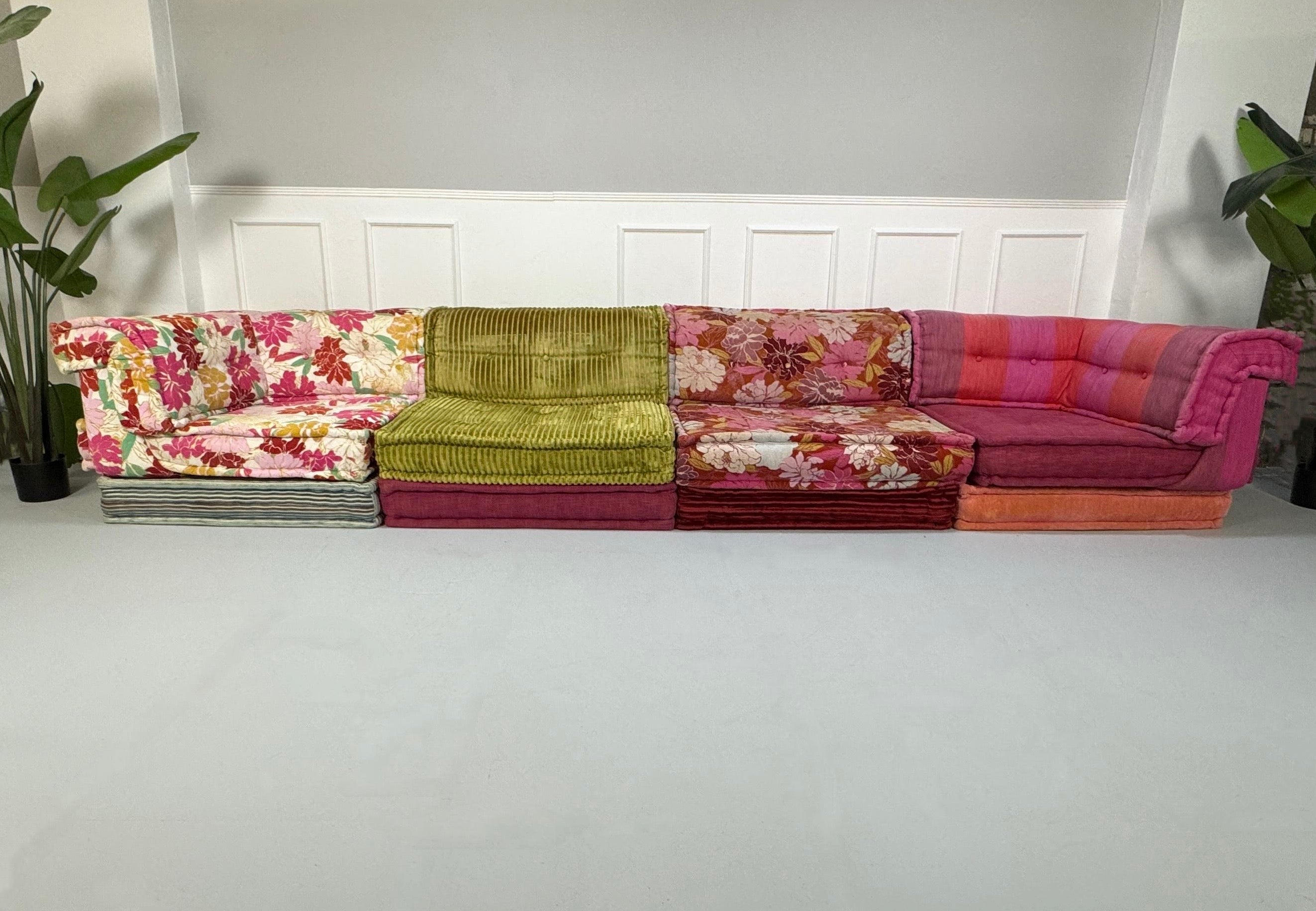 Gebrauchtes buntes Roche Bobois MahJongDesigner Stoff Sofa vor einer Wand, stilvoll und modern eingerichtet.