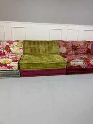 Gebrauchtes buntes Roche Bobois MahJongDesigner Stoff Sofa vor einer Wand, stilvoll und modern eingerichtet.