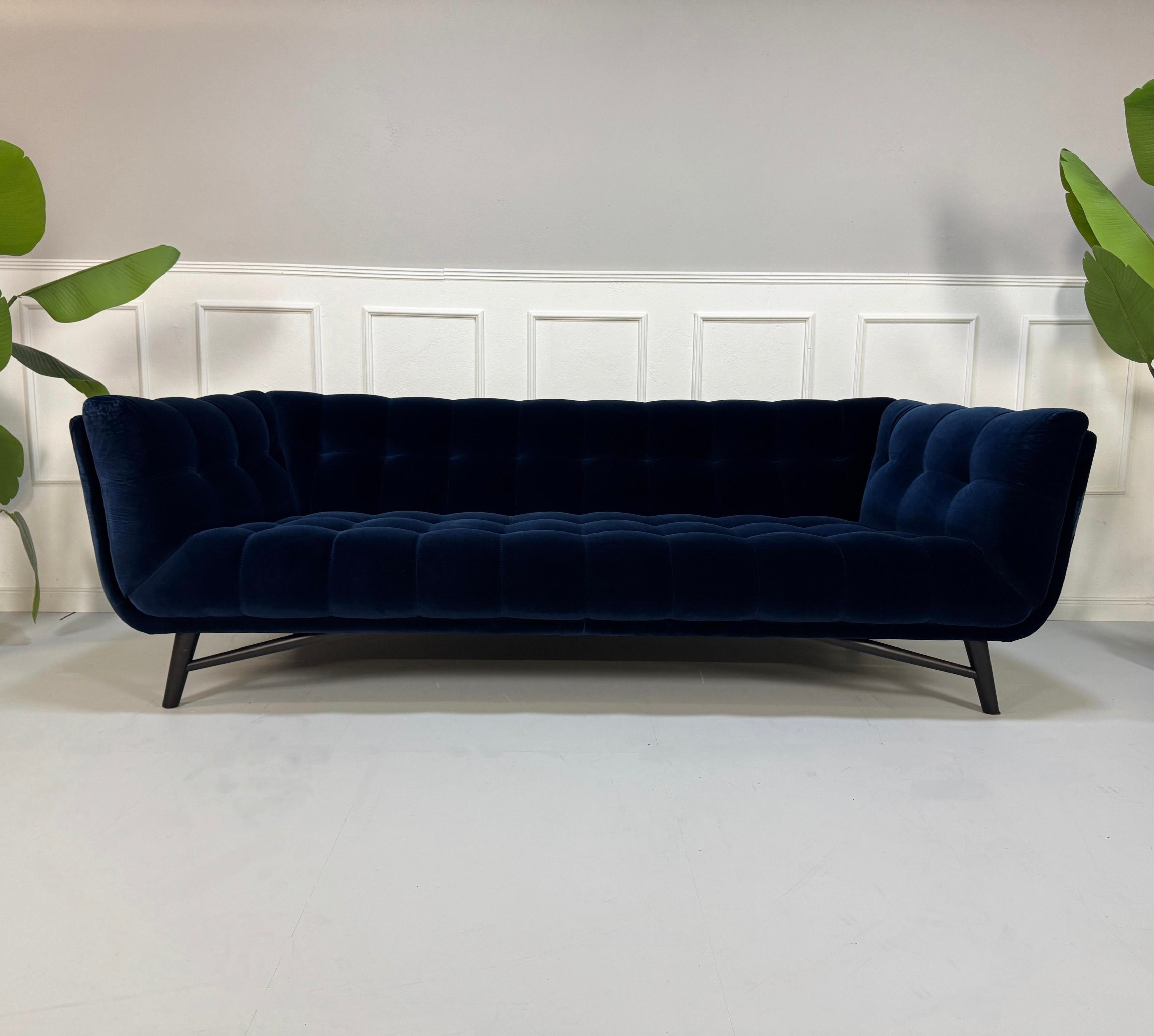 Gebrauchtes blaues Roche Bobois Profile Designer Stoff Sofa vor einer Wand, stilvoll und modern eingerichtet.