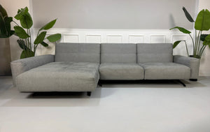Gebrauchtes graues Rolf Benz 50 Designer Stoff Sofa vor einer Wand, stilvoll und modern eingerichtet.