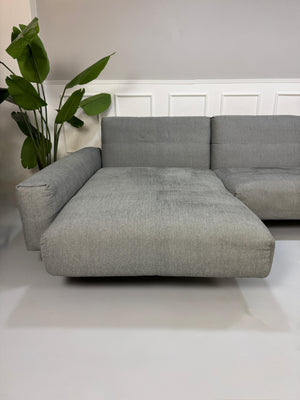 Gebrauchtes graues Rolf Benz 50 Designer Stoff Sofa vor einer Wand, stilvoll und modern eingerichtet.
