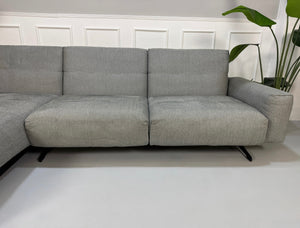 Gebrauchtes graues Rolf Benz 50 Designer Stoff Sofa vor einer Wand, stilvoll und modern eingerichtet.